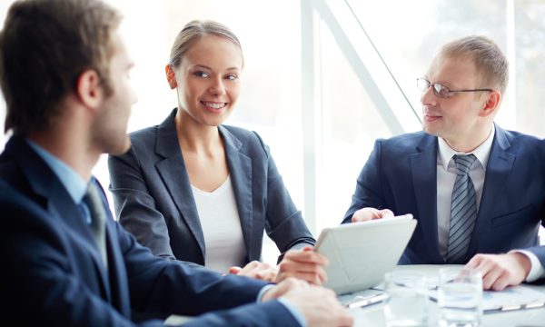Pretty secretary looking at one of partners while planning work at meeting